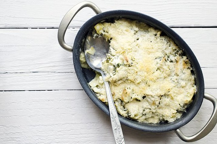 A freshly baked batch of cheesy kale and artichoke dip.