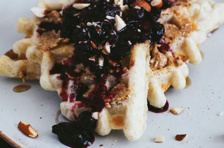 A stack of gluten-free waffles with a dollop of berry compote.