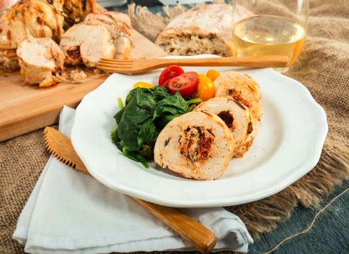 Plate of stuffed chicken breast with side salad.