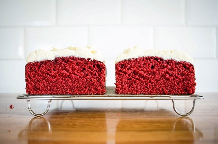 Slices of red velvet pound cake topped with white frosting.