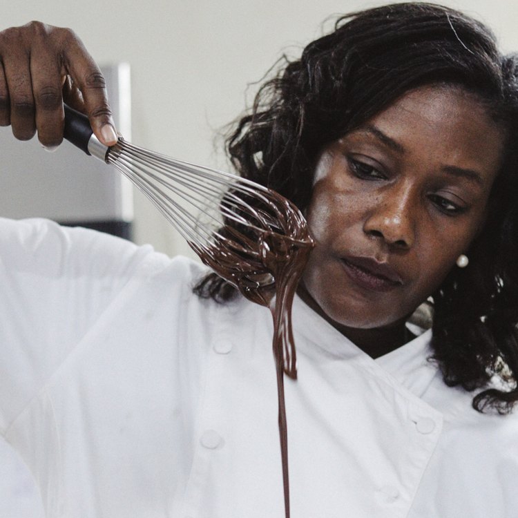 Chef holding whisk with melted chocolate