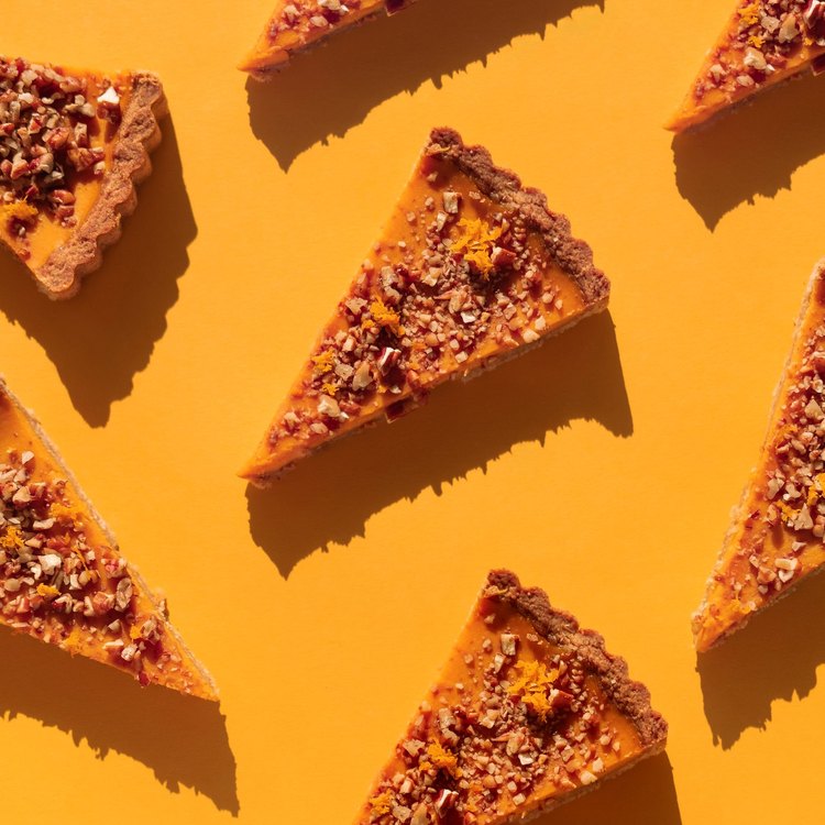 Thanksgiving pie slices against a bright orange background