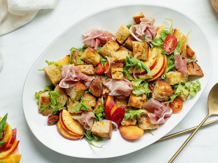 peach panzanella salad plated with serving cutlery